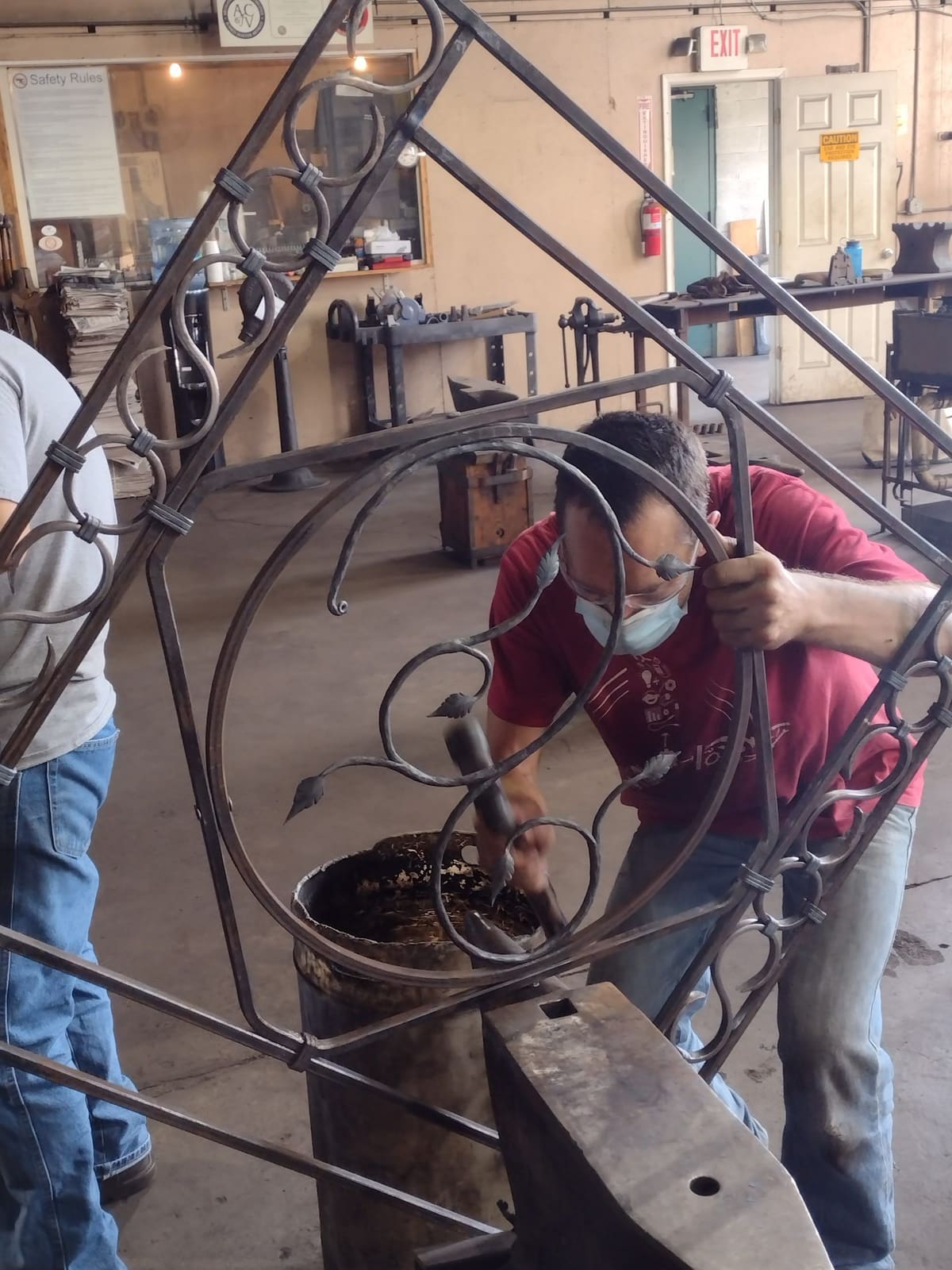 A student forging a large scroll at the anvil in the VIB shop